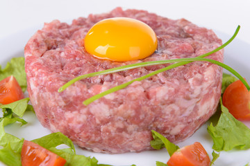 Delicious steak tartare with yolk on plate close-up