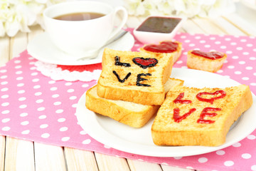 Delicious toast with jam and cup of tea on table close-up