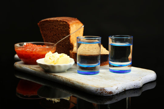 Composition with glasses of vodka, red caviar, fresh bread