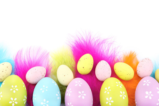 Easter eggs and decorative feathers, isolated on white