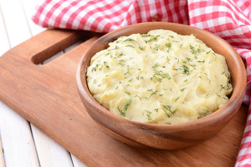 Delicious mashed potatoes with greens in bowl on table close-up