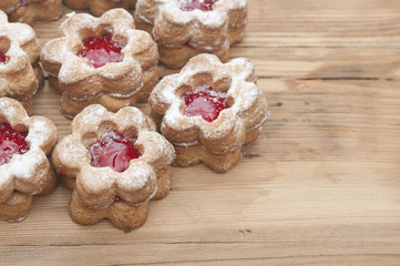 Flowers shape cookies cover with powder sugar on a wooden table