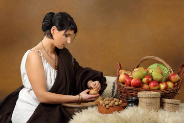 Young Romana peeling the onion with basket full of fruits and ve