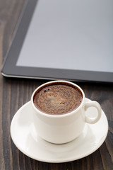 Fototapeta na wymiar Cup of coffee and tablet