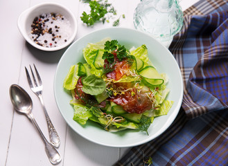 green salad with cucumber, crispy bacon and eggs