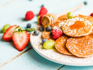Pancakes with berries on wooden background