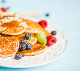 Pancakes with berries on wooden background
