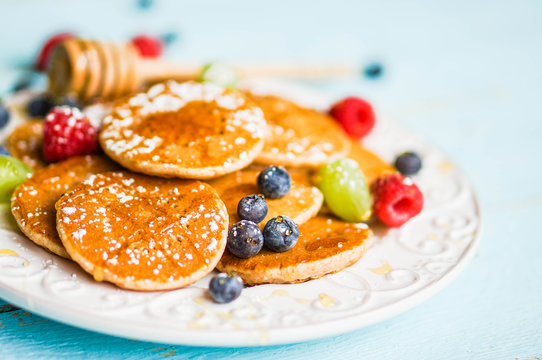 Pancakes with berries on wooden background