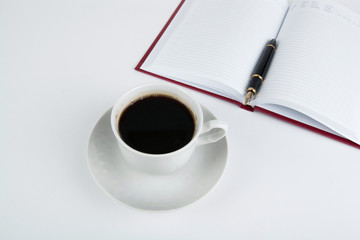 Obraz na płótnie Canvas Cup of coffee with diary with fountain pen