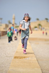 Young girl running on the beach of Caesarea