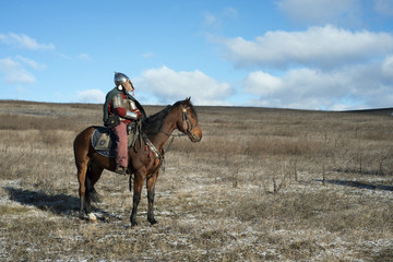 Ancient horseman in metal helmet observing steppe