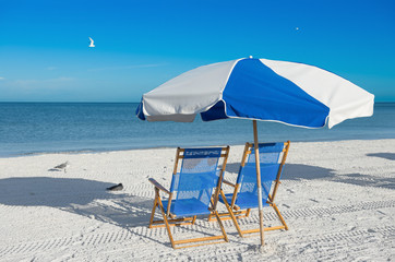sun loungers and a beach umbrella on silver sand, vacation