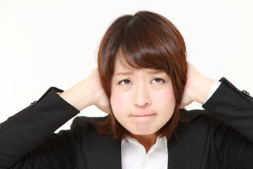 耳を塞ぐビジネスウーマン