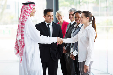group of businesspeople welcoming Islamic businessman