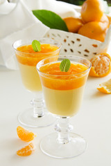 orange panna cotta with slices of oranges.