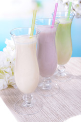 Milk shakes on table on light blue background