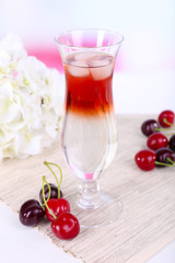 Glass of cocktail on table on light background