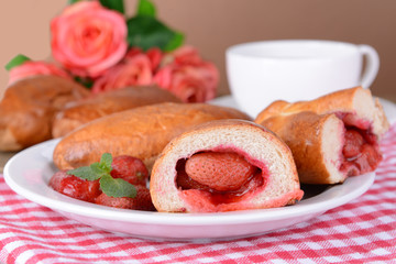 Fresh baked pasties with strawberries on plate on table