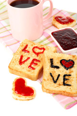 Delicious toast with jam and cup of tea on table close-up