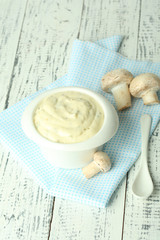 Delicate mushroom sauce in bowl on wooden table close-up
