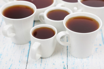 Many cups of tea on table close-up