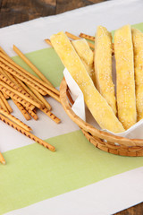 Bread sticks  in wicker basket on wooden background