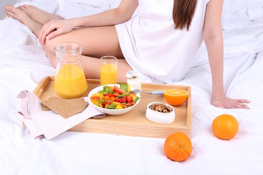 Woman in bed with light breakfast