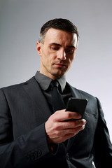 Businessman using smartphone over gray background