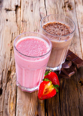 Fresh milk, strawberry and chocolate drinks on wodeen table