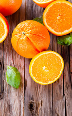 Fresh orange fruits and slices on wooden table. Wooden backgroun