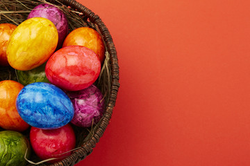 Ostereier im Korb vor rotem Untergrund