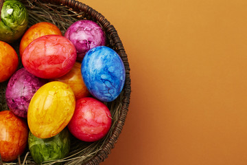 Ostereier im Korb vor braunem Untergrund