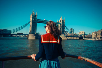Young woman on boat looking at Tower Bridge in London
