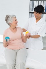 Fototapeta premium Doctor with senior patient using stress buster balls