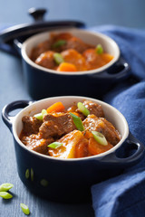 beef stew with potato and carrot in blue pots