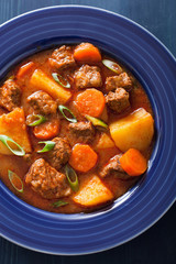 beef stew with potato and carrot in blue plate