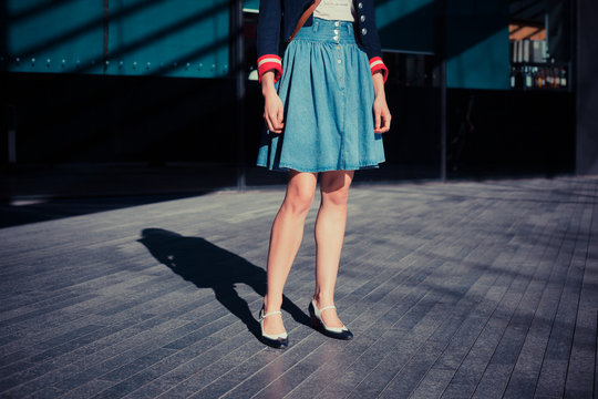 Young woman in skirt standing in the street