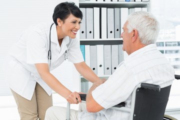 Obraz premium Female doctor talking to a senior patient in wheelchair