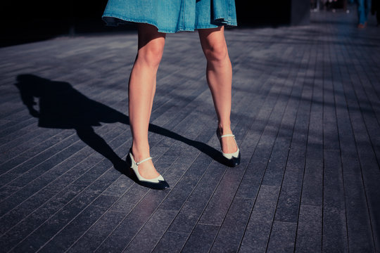 Young woman in skirt standing in the street