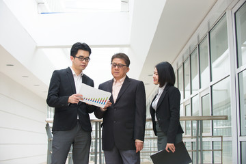 asian business team reporting to senior ceo with office backgrou