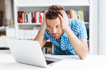 Worried man looking on laptop