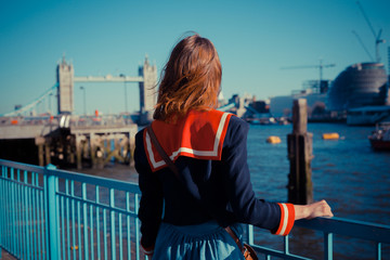 Young woman standing on the bank of the Thames in London