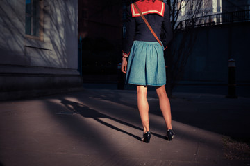 Young woman standing in the street at sunset