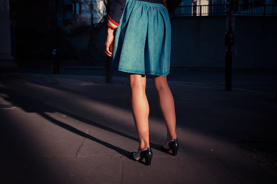 Young woman standing in the street at sunset