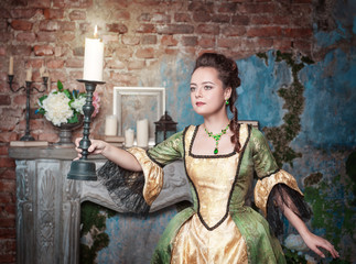 Beautiful woman in medieval dress with burning candle