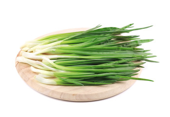 Bunch of green onion on wooden platter.