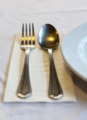 Fork, spoon and white dish.