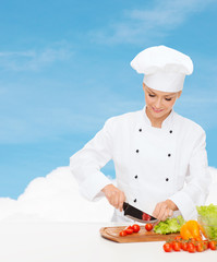 smiling female chef chopping vagetables
