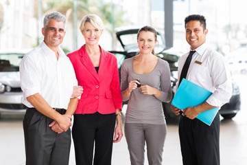 family buying a new car at vehicle dealership