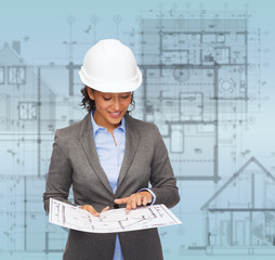 businesswoman in white helmet with blueprint